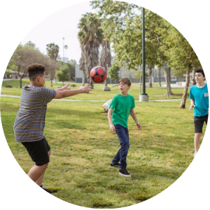 photo boys playing soccer in park photo boys playing soccer in park